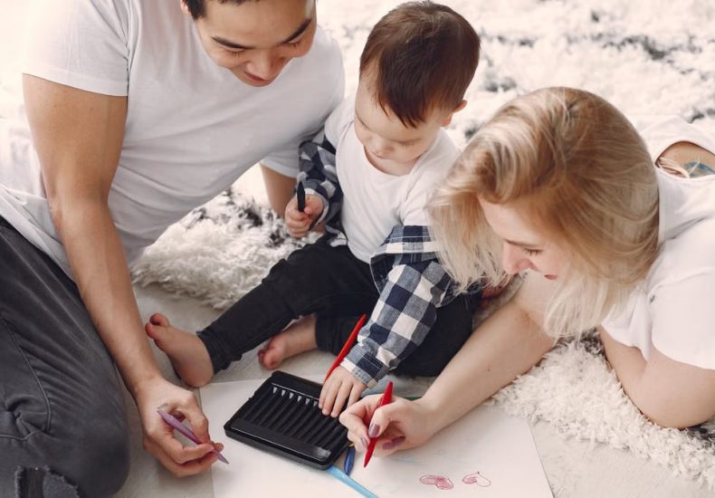 Parents and child enjoying drawing together on the floor, creating memories.